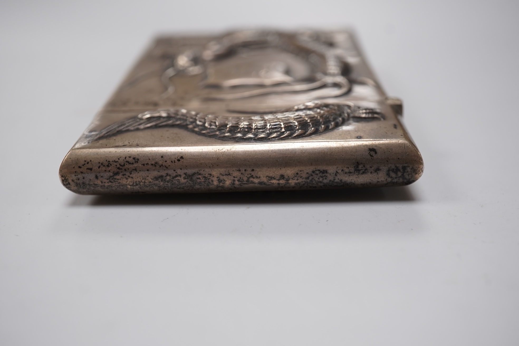 A late 19th century Chinese Export white metal card case, by Cum Shing, Canton, embossed with a dragon and applied shield shaped panel engraved with monogram, 90mm, 85 grams.